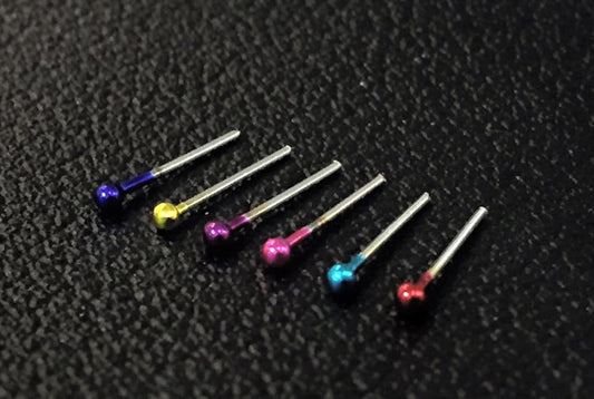 Surgical steel nose piercing with colored dots.